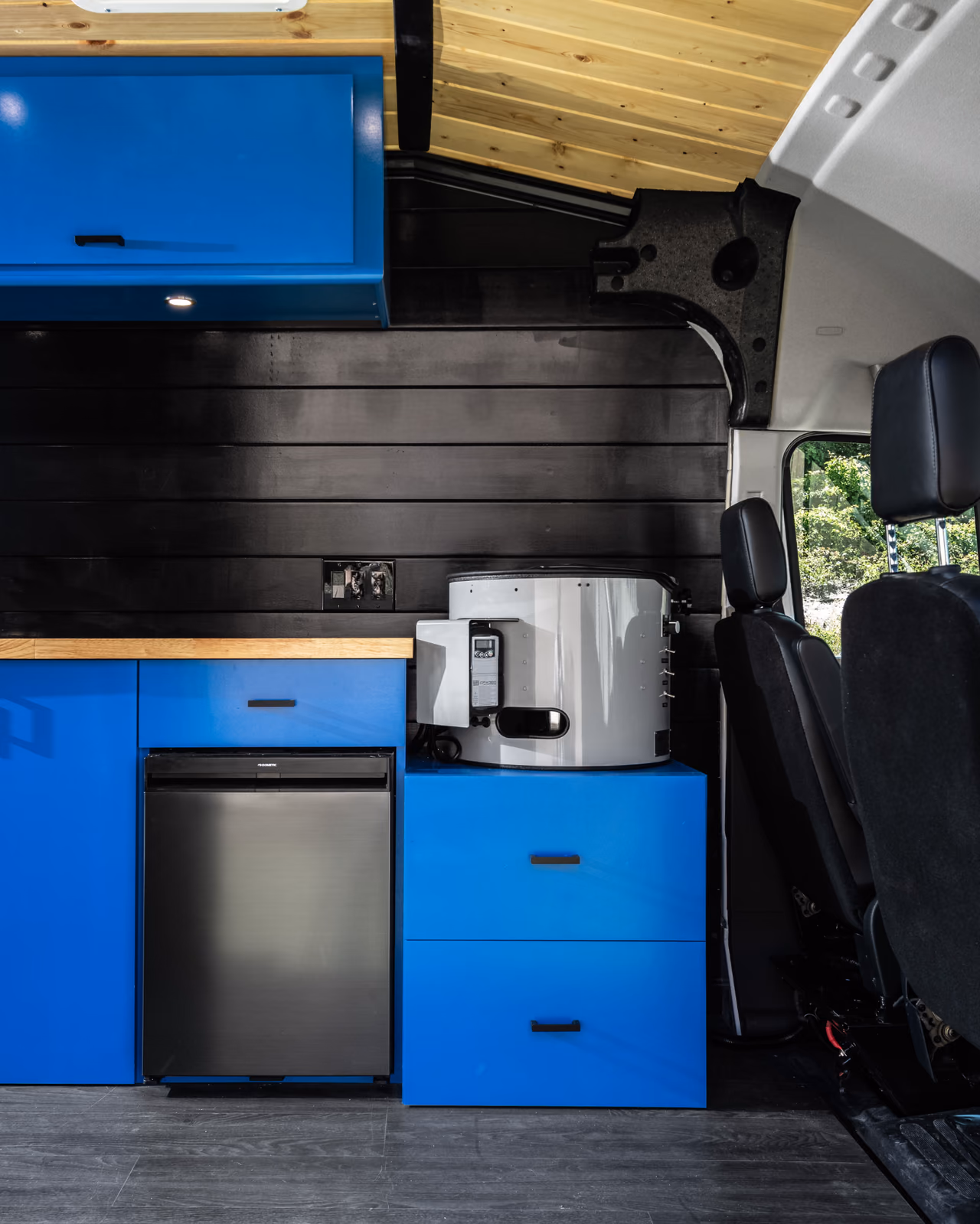 Full interior of the Sheer Craftsmen mobile sharpening van with a workbench and storage cabinets.