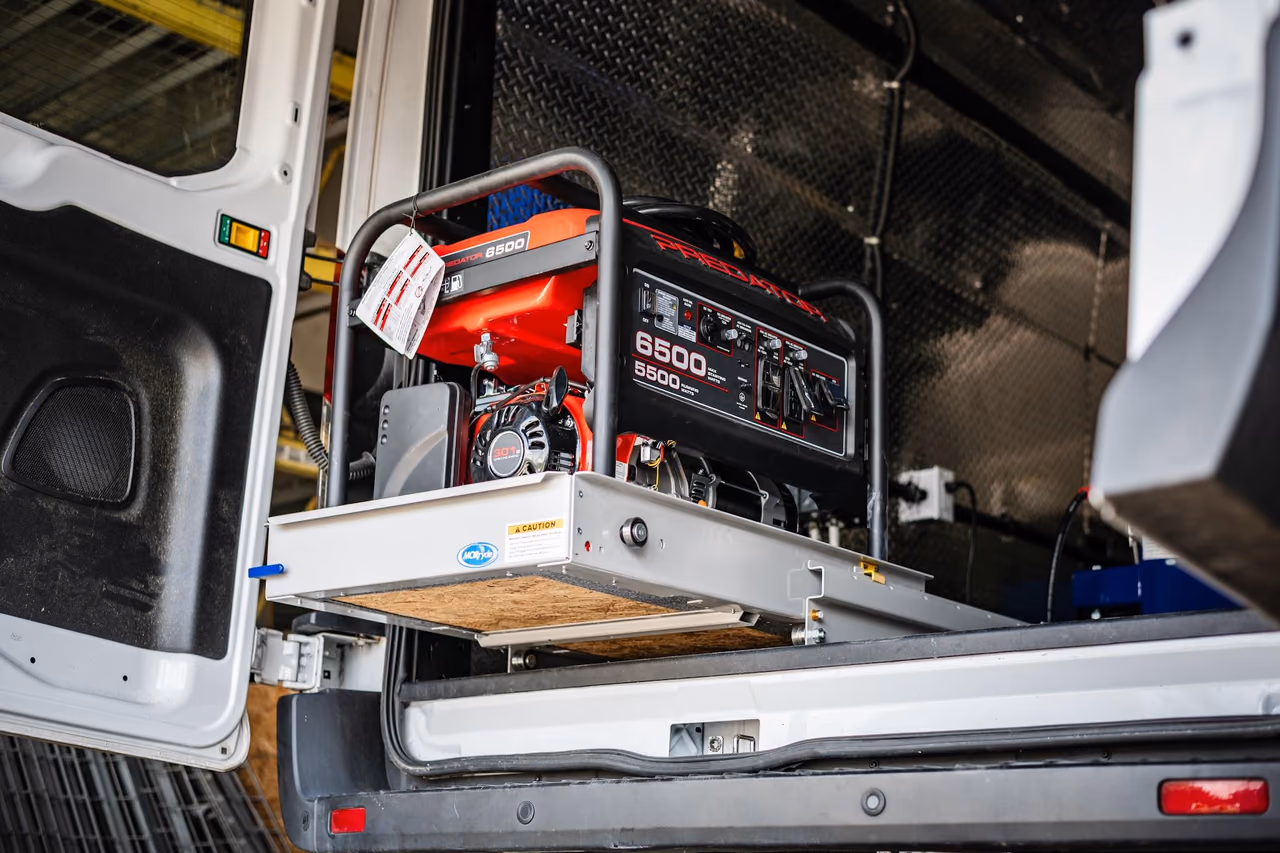 Generator on an extended slide-out tray at the rear of the custom mobile tire service van.